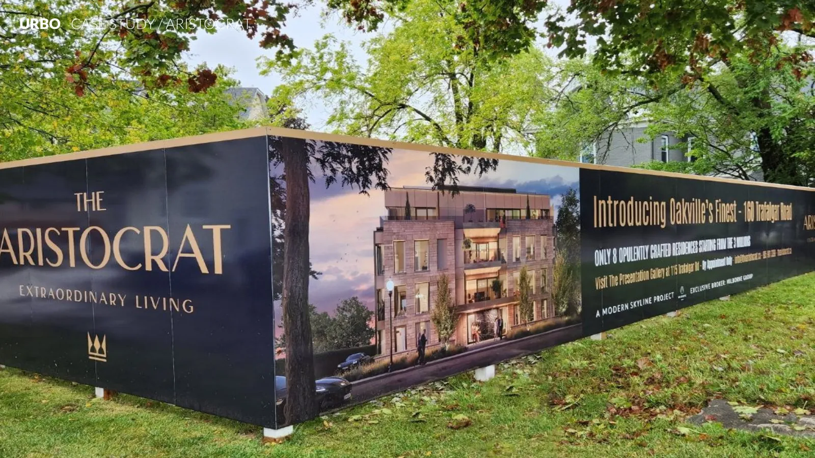 Aristocrat hoarding panels installed along a grassy roadside, with the wordmark and building rendering